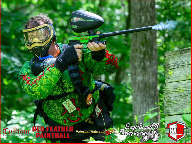 Red Feather paintball Player is in action wearing a green paintball jersey from custompaintball.co company